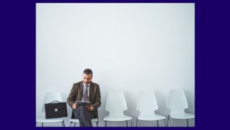 man in waiting room with briefcase beside him