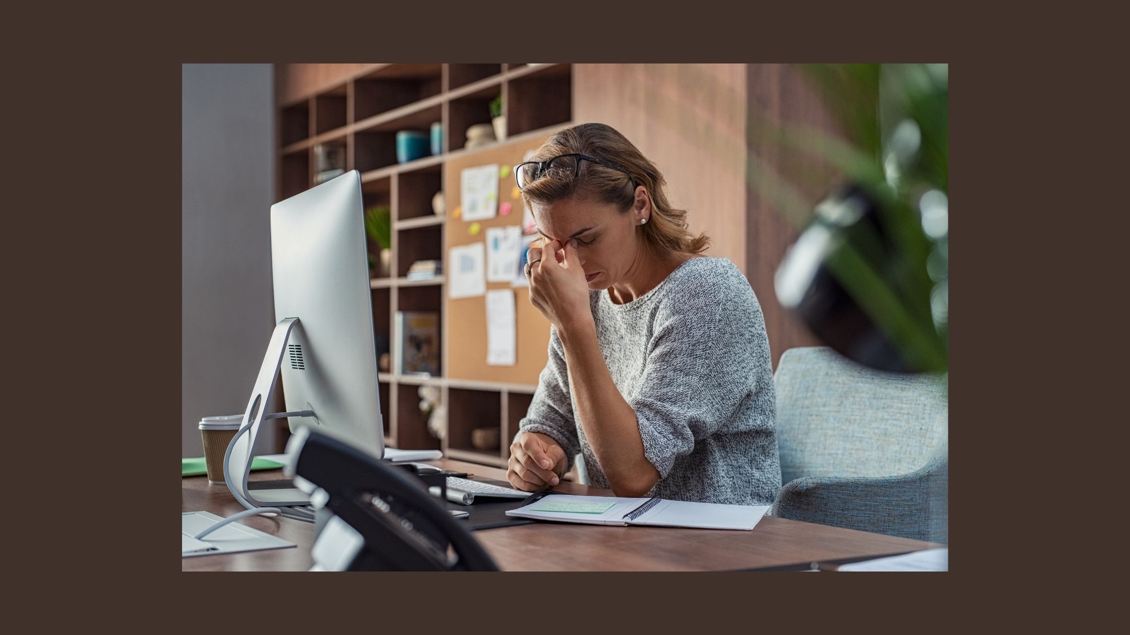 person at desk looking tired and overwhelmed