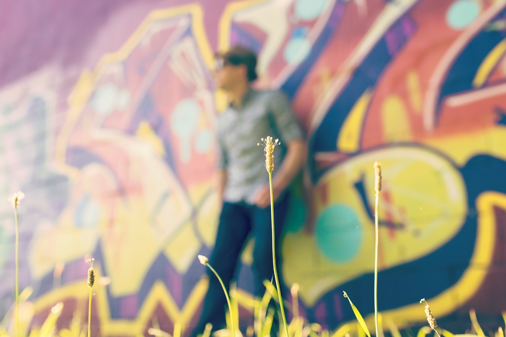 Man leaning on wall of graffiti