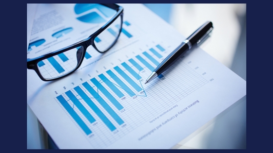 glasses and a pen on top of a paper report