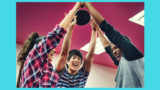 young people holding ping pong rackets