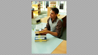 person at desk checking out books