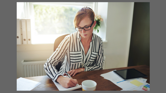 woman sitting at desk writing